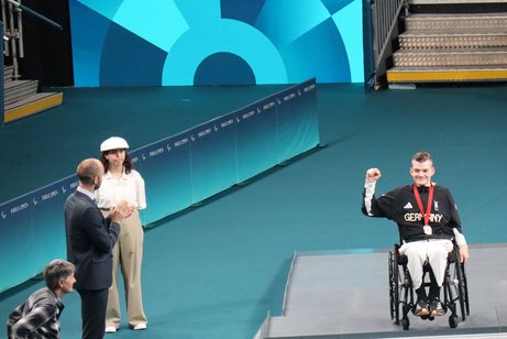 Thomas Schmidberger bei den Paralympics Thomas Schmidberger (rechts im Rollstuhl) hält seine Medaille hoch.