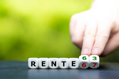 Rente mit 63 oder 67? Eine Hand dreht einen Buchstaben-/Zahlen-Würfel und ändert den Ausdruck "Rente 67" in "Rente 63"