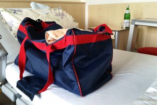 Gepackte Reisetasche auf Krankenhausbett