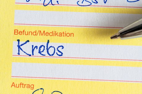 Eine ärztliche Bescheinigung, bei der unter Befund/Medikation das Wort "Krebs" eingetragen ist.