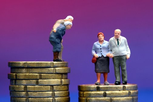 Kleine Fig&uuml;rchen von Senioren stehen auf unterschiedlich hohen M&uuml;nzstapeln aus Euro Cent M&uuml;nzen.