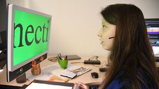 Eine Mitarbeiterin des Unternehmens TE Connectivity sitzt in ihrem Büro am PC, sie nutzt eine Funktion um den Bildschirm barrierefrei mit stark vergrößerter Schrift darzustellen. 