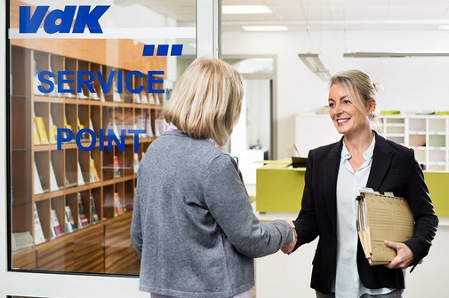 VdK-Beratungsstelle Eine VdK-Mitarbeiterin begrüßt eine Frau an der Tür einer VdK-Beratungsstelle. Sie hat eine Aktenmappe unter dem Arm.