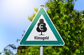 Die Bildmontage zeigt ein Verkehrsschild mit einem Baum, einem Euro-Zeichen und der Aufschrift "Klimageld". 