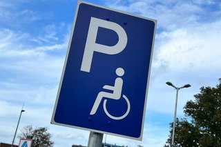 Ein Schild weist einen Behindertenparkplatz aus.