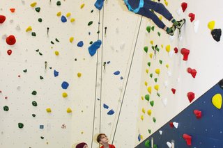 Auf dem Foto sieht man die Kinder der therapeutischen und inklusiven Kletterkurse an der Kletterwand.