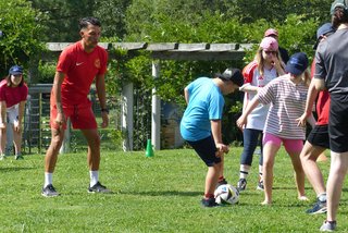 Teilnehmende der Freizeit spielen mit Ex-Bundesligaprofi Patrick Ghigani (links im Bild) Fußball.