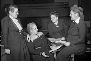 Das Foto zeigt die vier weiblichen Abgeordneten des Parlamentarischen Rates (v.l.n.r.) Helene Wessel (1898-1969, Zentrumspartei), Helene Weber (1881-1962, CDU), Friederike Nadig (1897-1970, SPD) und Elisabeth Selbert (1896-1986, SPD) in der Aula der Pädagogischen Akademie.