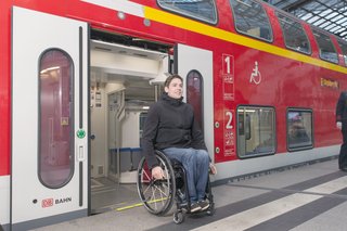 Ein junger Mann, der im Rollstuhl sitzt, verlässt gerade die Bahn durch die Tür. 