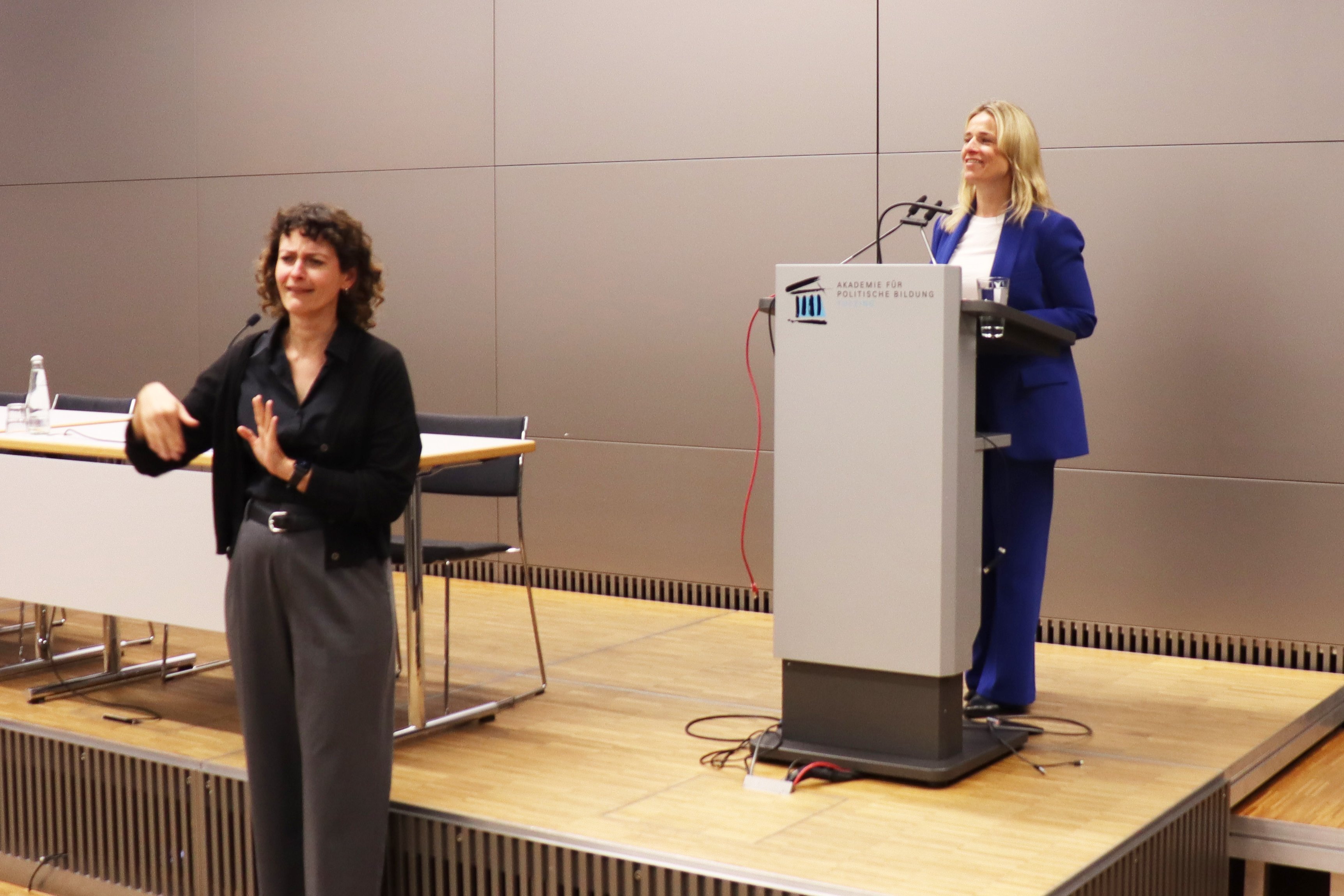 VdK-Landesvorsitzende Verena Bentele bei ihrem Vortrag (rechts), der auch in Geb&auml;rdensprache &uuml;bersetzt wurde.