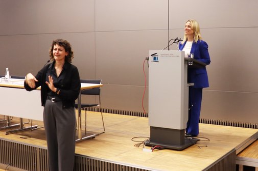 VdK-Landesvorsitzende Verena Bentele bei ihrem Vortrag (rechts), der auch in Geb&auml;rdensprache &uuml;bersetzt wurde.