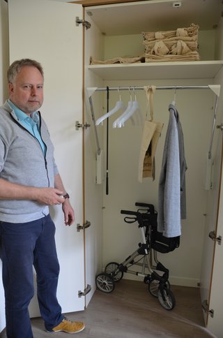 Auf dem Foto sieht man Volker Bertram, Mitarbeiter der Seniorenberatung, der demonstriert, wie eine Kleiderstange auf Knopfdruck herunterfährt.