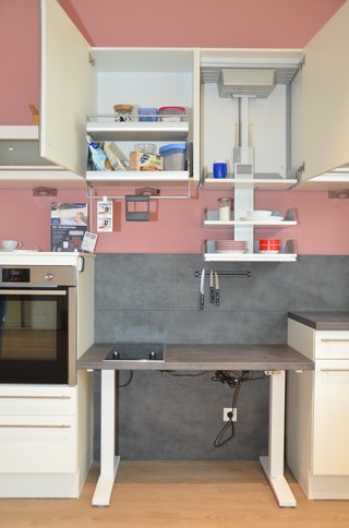 Auf dem Foto sieht man offene Schränke und Regale in einer Küche einer Musterwohnung. 