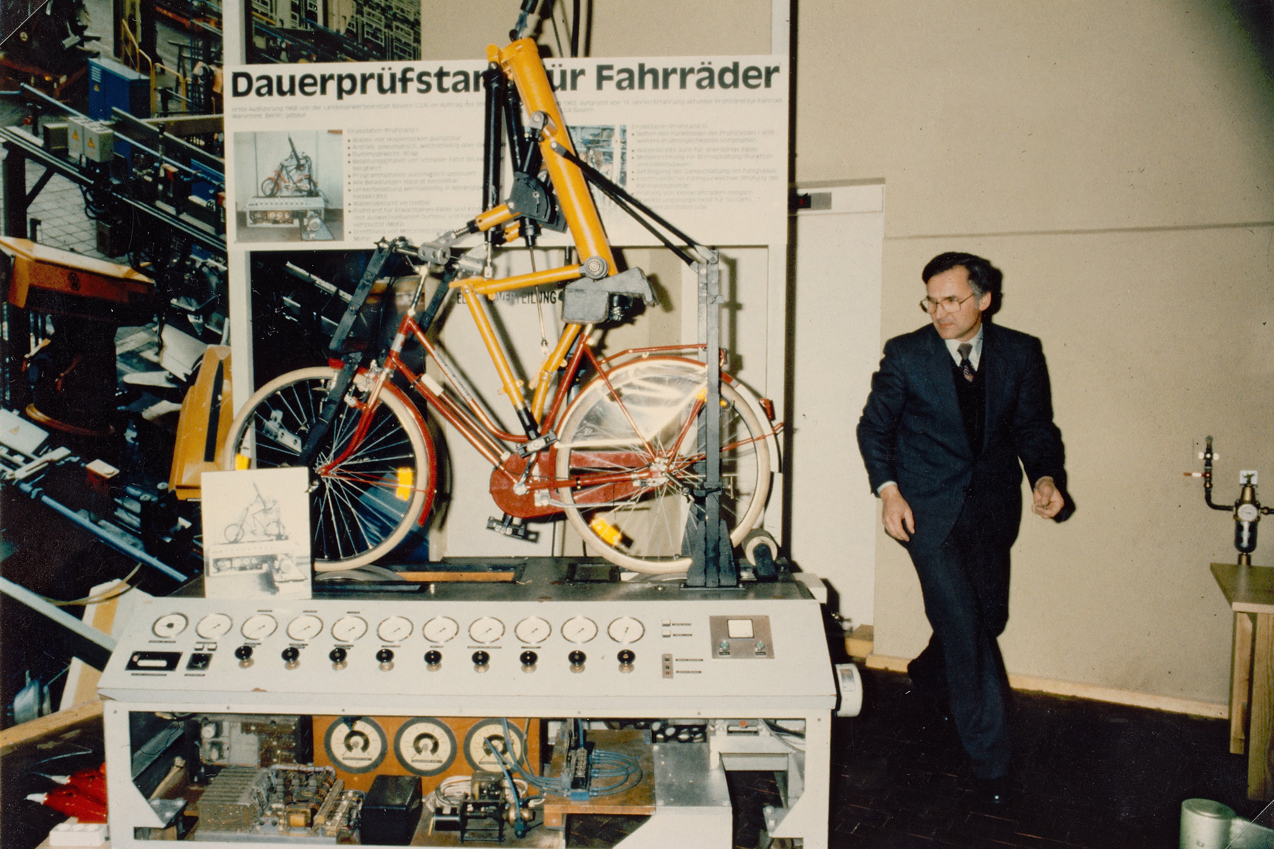 Foto von 1974. Man sieht einen Mann neben einer Prüfmaschine mit einem Fahrrad stehen.