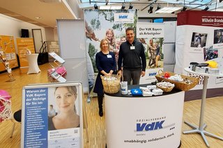 Auf dem Foto sieht man Carsten Vetter, VdK-Bezirksgeschäftsführer Unterfranken, und Anja Scheffel-Meistel von der Personalabteilung des VdK Bayern auf der studentischen Firmenkontaktmesse am Messestand stehen.