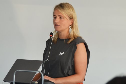 VdK-Landesvorsitzende Verena Bentele steht am Podium und spricht in das Mikro.