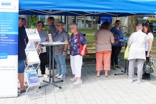 Auf dem Foto sieht man Besucherinnen und Besucher am Infostand des Ortsverbands Waldkraiburg auf dem Waldkraiburger Wochenmarkt.