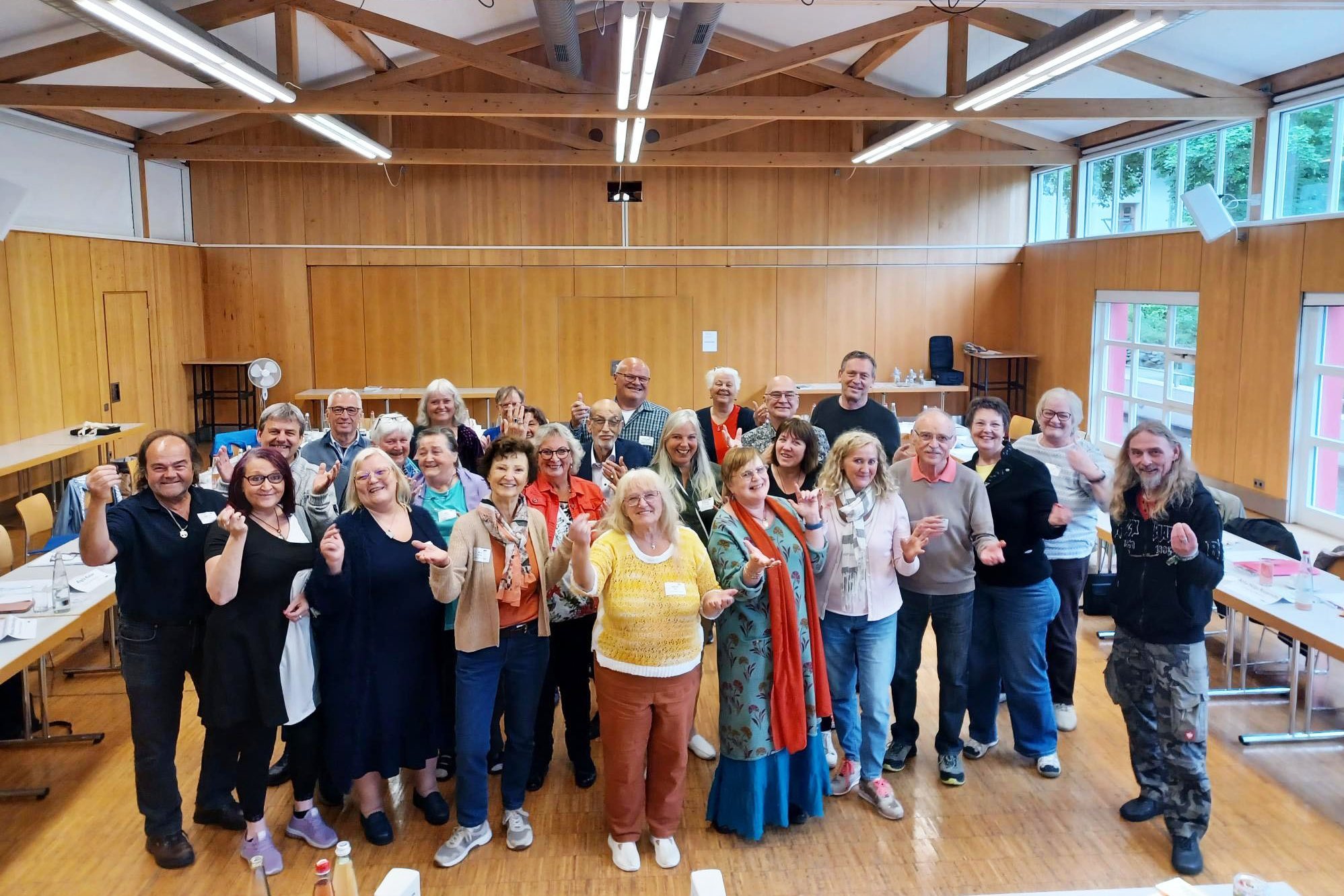 Eine Gruppe von M&auml;nnern und Frauen verschiedenen Alters hat sich in einem Seminarraum zu einem Gruppenbild aufgestellt und blickt fr&ouml;hlich-motiviert in die Kamera. Das Bild ist im Rahmen eines Rhetorik-Seminars des VdK Bayern f&uuml;r Ehrenamtliche entstanden. 