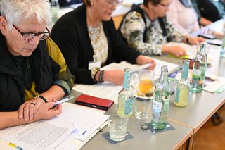 Auf dem Foto sieht man vier Teilnehmerinnen der Landesfrauenkonferenz. Sie sitzen an einem Tisch und lesen sich die Resolution durch.