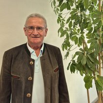 Ein Mann neben einer Zimmerpflanze