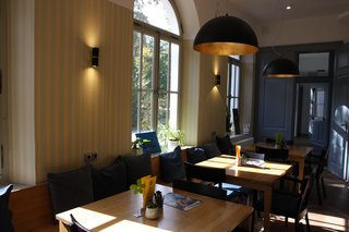 Auf dem Foto sieht man den Innenraum des Cafés "Café Vielfalt". Es stehen Tische und Stühle im Raum.