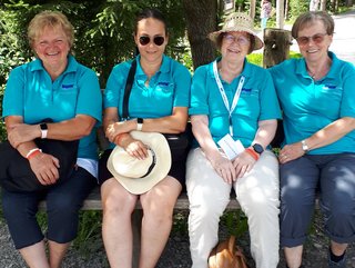 Vier Frauen die ein VdK-Poloshirt tragen, sitzend auf einer Bank