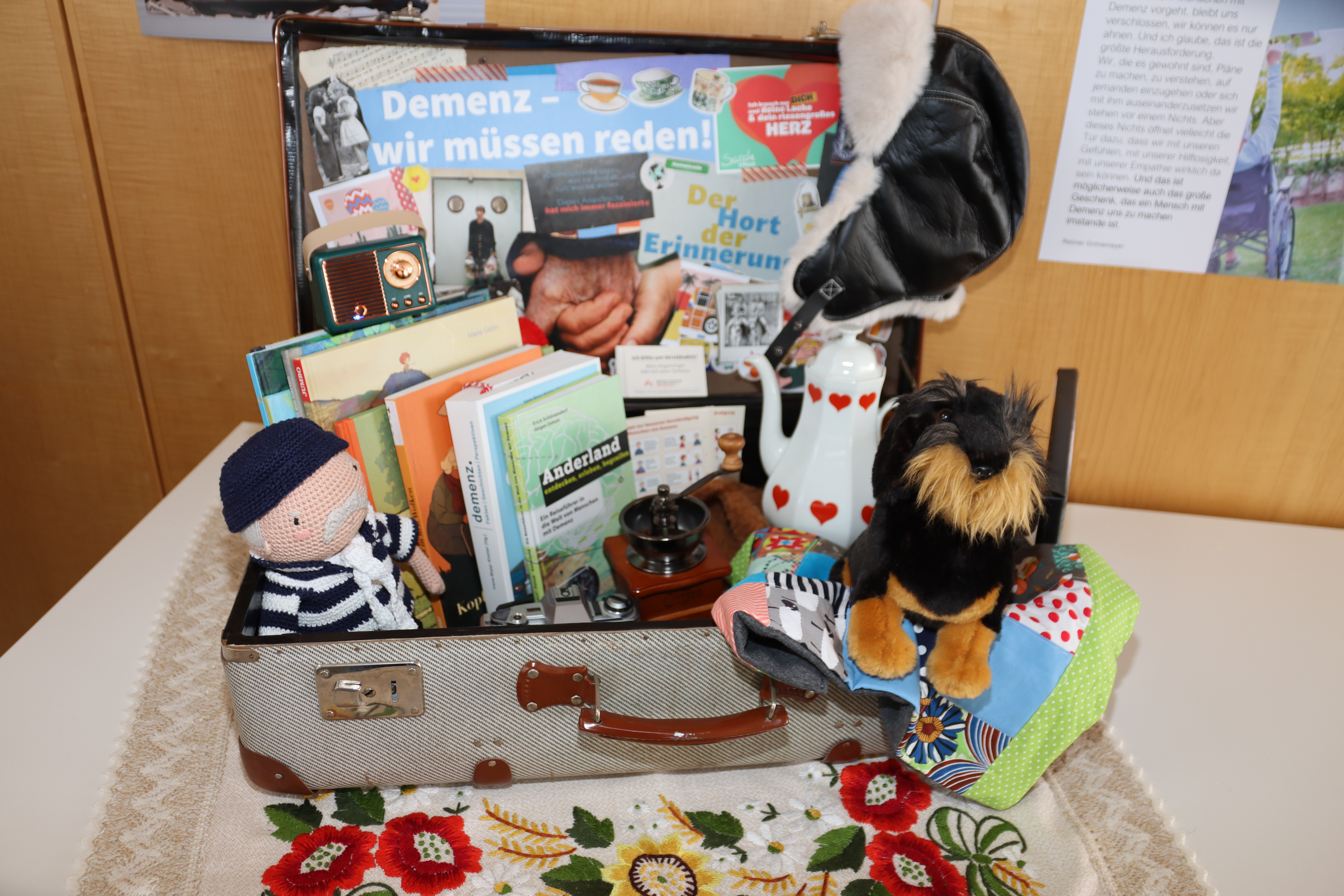 Auf dem Foto sieht man einen "Demenzkoffer". Im Gepäck ist eine Hand-Kaffeemühle, ein alter Fotoapparat, ein Kuscheltier und Sachbücher über Demenz. 