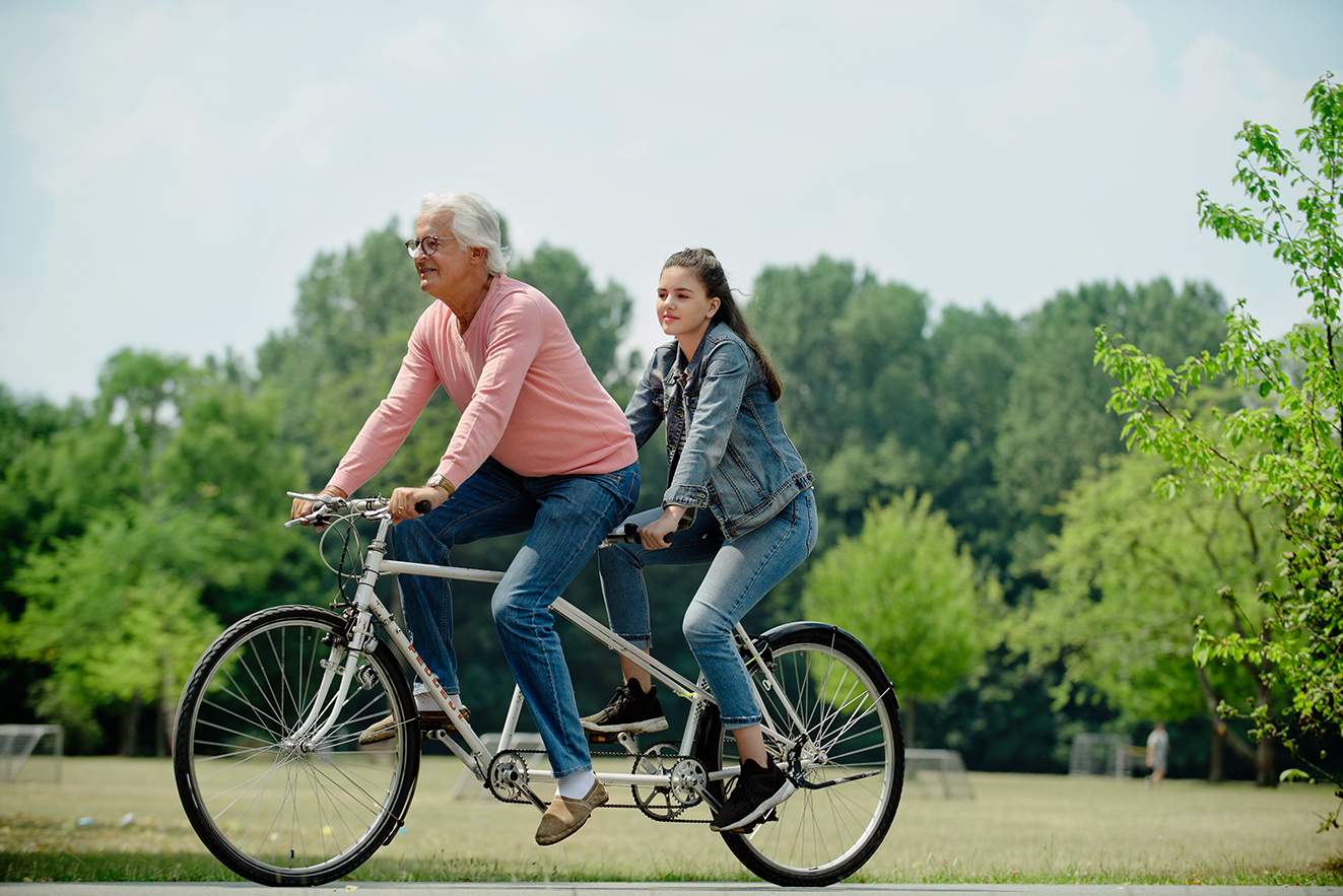 Ein &auml;lterer Mann und eine Teenagerin fahren gemeinsam auf einem Tandem.