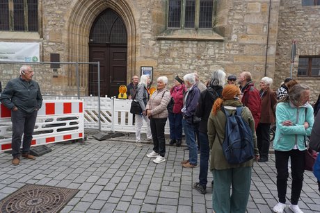 Einige Mitglieder vor dem Eingang einer Kirche.