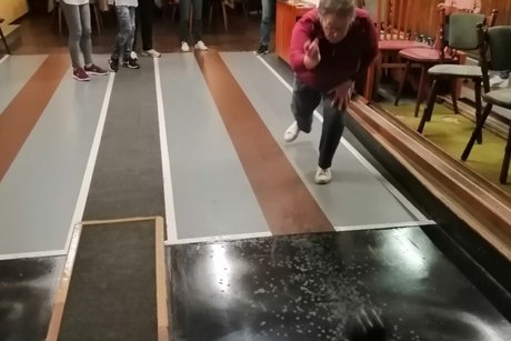 Auf geht's: Alle Neune Eine Teilnehmerin rollt die Kugel auf die Kegel zu