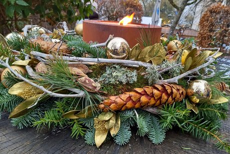 brennende Kerze auf einem Adventsgesteck