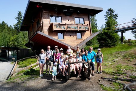 Eine Gruppe mit vielen KIndern vor dem Haus am Kopf