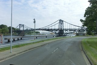 Auf dem Bild ist zu sehen: Die Kaiser-Wilhelm-Brücke in Wilhelmshaven. Sie ist eine achsensymmetrische, zweiflügelige Straßendrehbrücke aus genietetem Stahlfachwerk. Sie ist das Wahrzeichen der Stadt Wilhelmshaven.