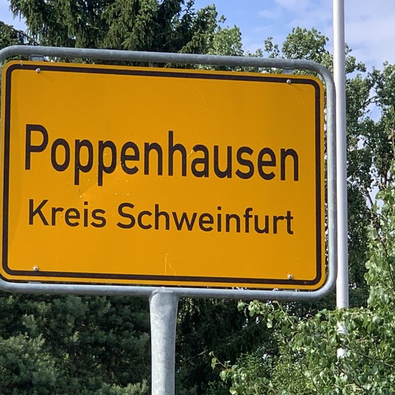 Das Foto zeigt das Ortsschild der Gemeinde Poppenhausen