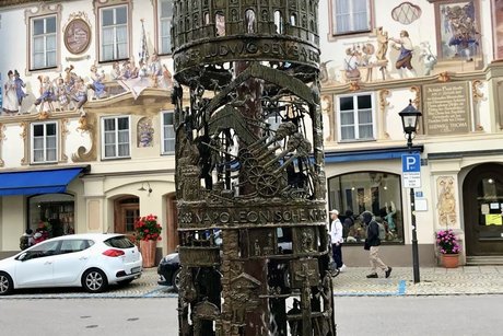 ein Bild vom Bronzebrunnen mit Motiven zur Geschichte von Oberammergau