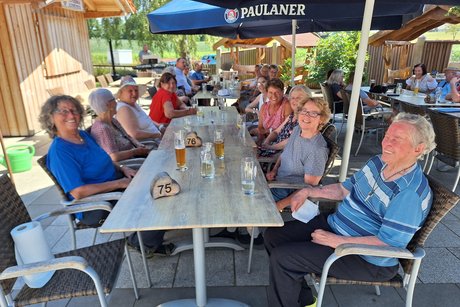 Biergartenbesucher im Schatten der Sonnenschirme