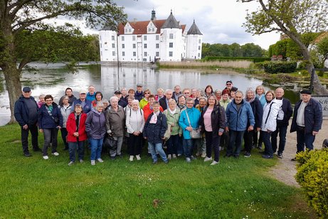 Die Reisegruppe des VdK vor einem See mit einem Schloss im Hintergrund