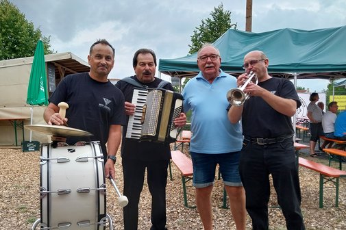 Gruppenbild mit drei Musikern und dem Ortsvorsitzenden