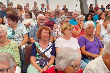 Zuschauer sitzen auf der Tribüne des Freilichttheaters in Wunsiedel