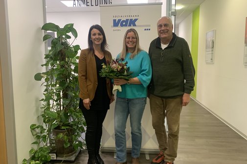 von links: Anna Ortmann, Anika Haid, Dirk Brosge 3 Personen. In der Mitte die geehrte Frau mit Blumenstrauß