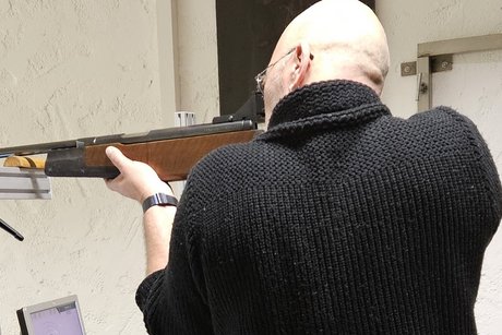 ein Mann mit Luftgewehr im Anschlag