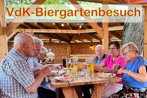 Menschen sitzen in gem&uuml;tlicher Runde im Biergarten