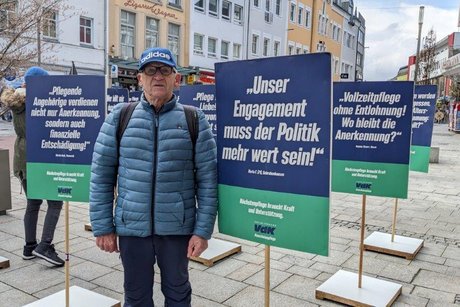 Abgebildet ist ein Passant mit den Schildern der stillen Demo