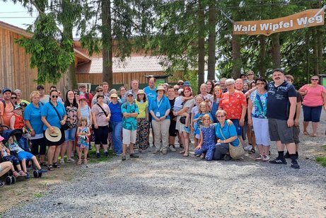Viele Familien mit Kindern stehen vor dem Eingang zum Waldwipfelweg