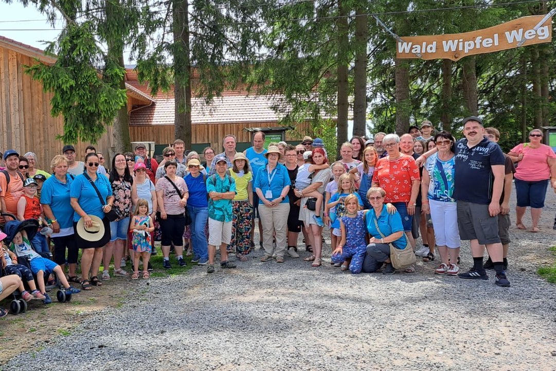 Viele Familien mit Kindern stehen vor dem Eingang zum Waldwipfelweg