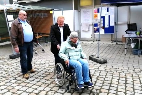Herr Bürgermeister Klement erprobt den Rollstuhl auf Kopfsteinpflaster Herr Bürgermeister Klement fährt Frau Minks im Rollstuhl über Kopfsteinpflaster