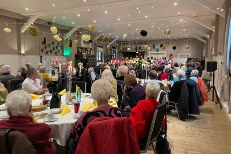 Saal mit zahlreichen G&auml;sten an Tischen