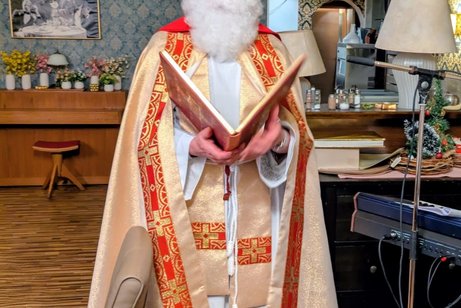 Bischof Nikolaus liest aus einem gro&szlig;en Buch