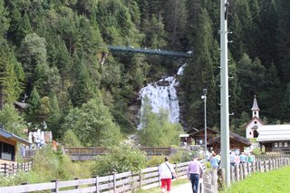 Im Mühlendorf, im Hintergrund der Wasserfall mit der 40 m langen Schluchtbrücke