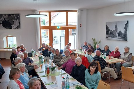 Mitglieder sitzen im Vortragsraum und unterhalten sich